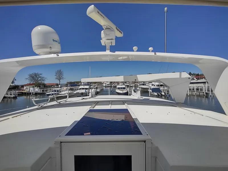 Slide: The Image of 1995 Hatteras 52 Cockpit Motor Yacht docked at marina under clear blue sky. - 9