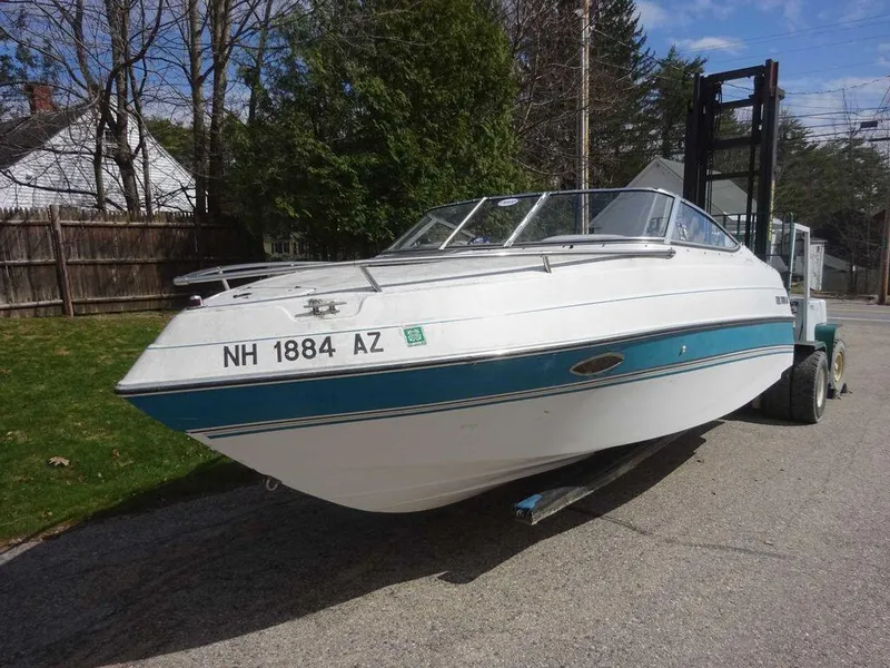 Slide: The Image of 1995 Four Winns 205 Sundowner boat on a forklift, white with blue stripe. - 16