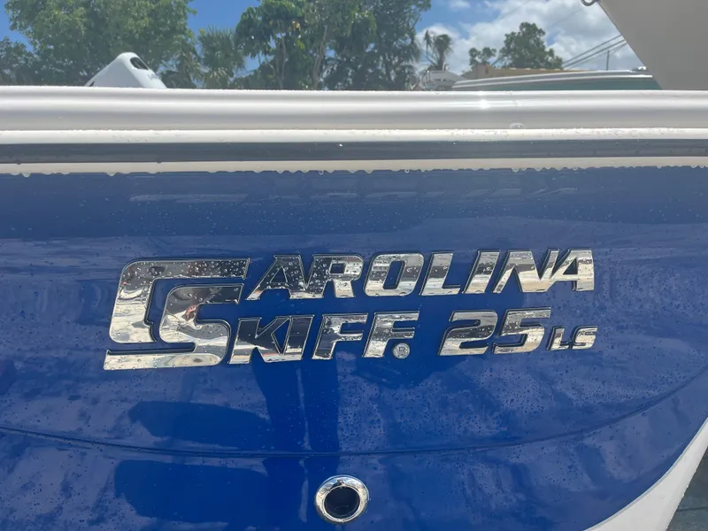 Slide: The Image of 2024 Carolina Skiff 25 LS boat logo on blue hull. - 2