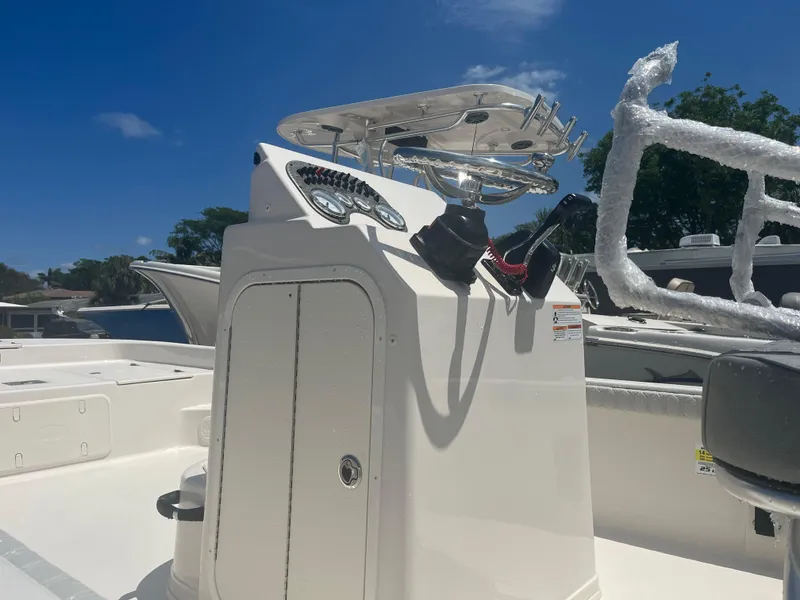 Slide: The Image of 2024 Carolina Skiff 25 LS center console boat with T-top under clear blue sky. - 8