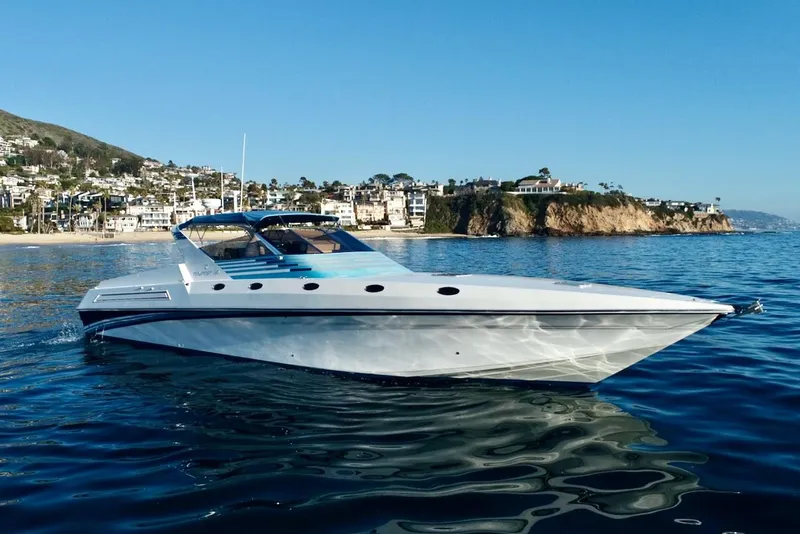 Slide: The Image of 1990 Tempest Offshore Sport Yacht cruising near coastal homes. - 0