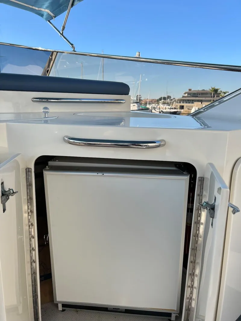 Slide: The Image of 1990 Tempest Offshore Sport Yacht with open storage compartment and marina view. - 10