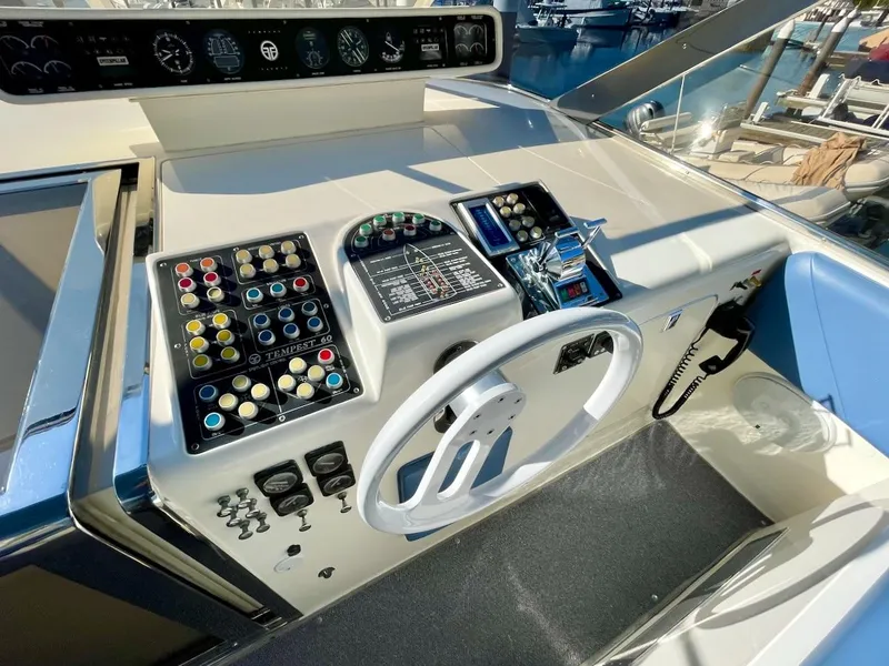 Slide: The Image of 1990 Tempest Offshore Sport Yacht helm with control panel, steering wheel, and navigation instruments. - 12