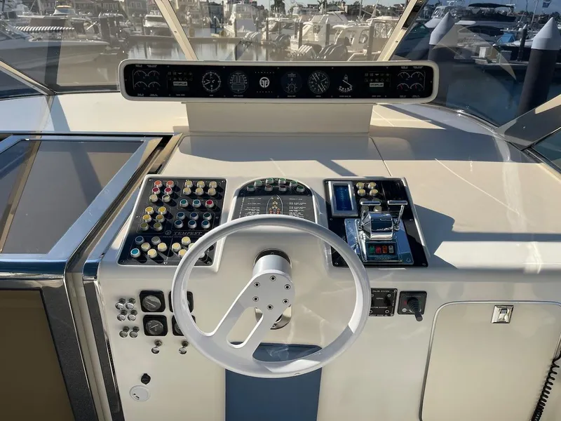 Slide: The Image of 1990 Tempest Offshore Sport Yacht helm with steering wheel and control panel. - 13