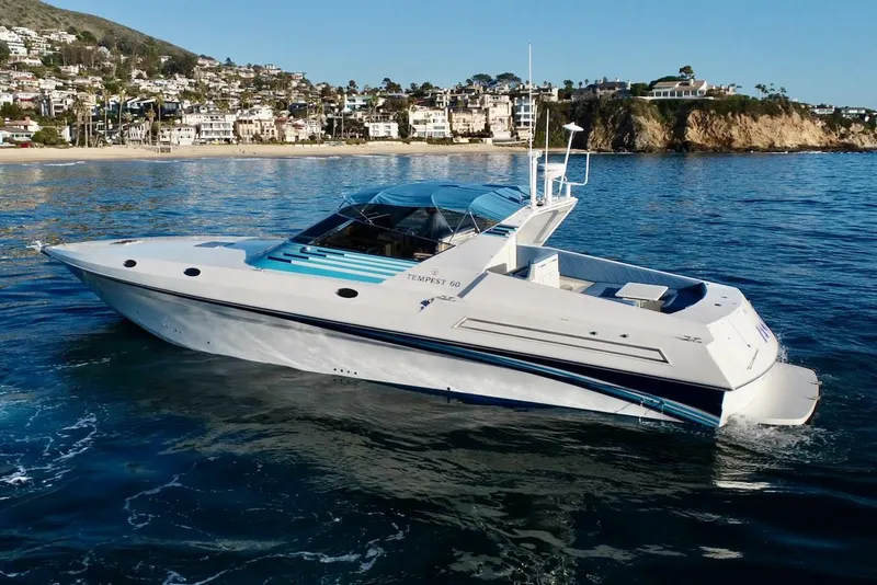 Slide: The Image of 1990 Tempest Offshore Sport Yacht cruising near a coastal town. - 2