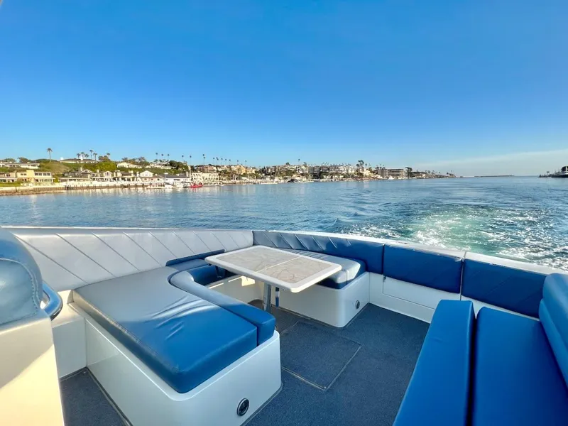 Slide: The Image of 1990 Tempest Offshore Sport Yacht cruising near coastal homes on a sunny day. - 6