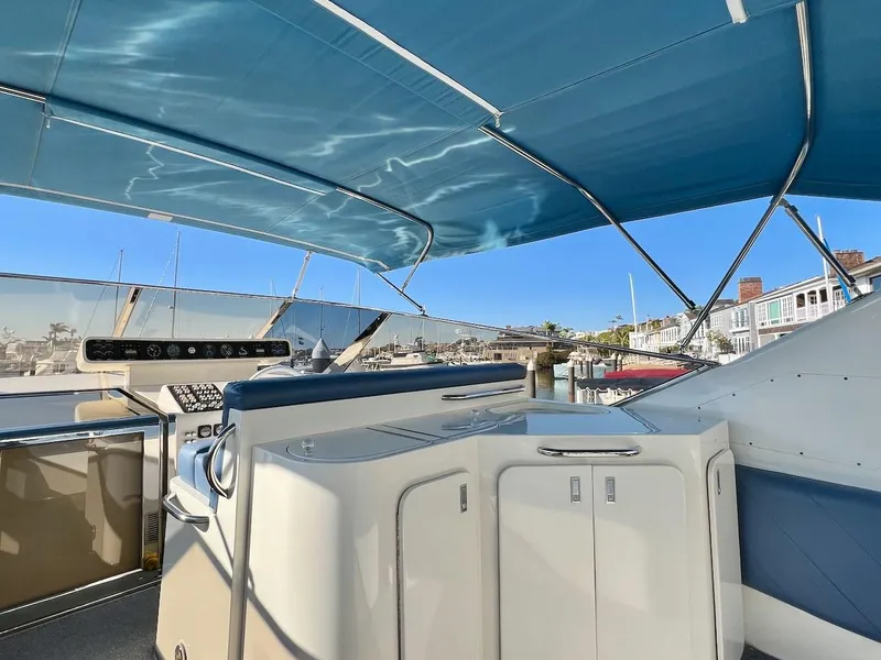 Slide: The Image of 1990 Tempest Offshore Sport Yacht cockpit with blue canopy, docked in a marina. - 8