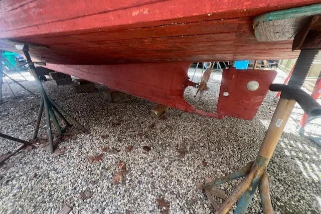 Slide: The Image of 1972 Grand Banks Trawler underbody on stands, showing red hull and propeller. - 20