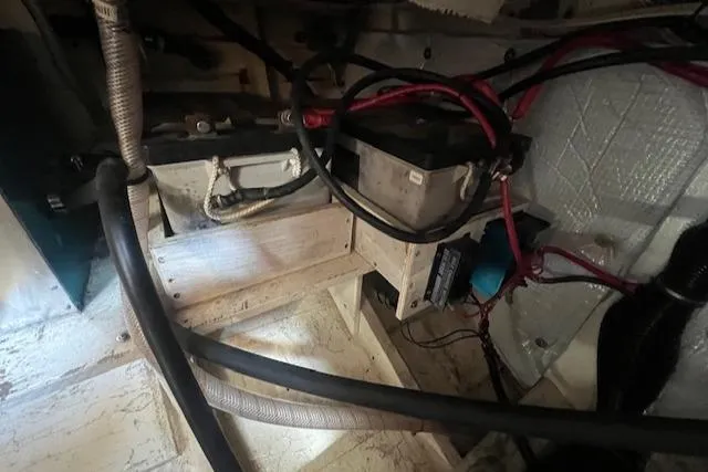 Slide: The Image of Engine compartment of a 1972 Grand Banks Trawler, featuring wiring and battery components. - 14