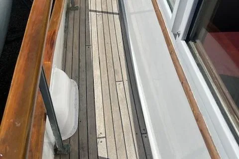 Slide: The Image of Wooden deck of a 1972 Grand Banks Trawler with polished railings. - 17