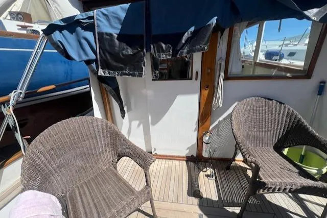 Slide: The Image of 1972 Grand Banks Trawler deck with wicker chairs and blue canopy. - 18