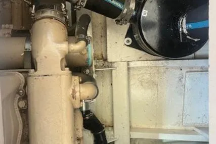 Slide: The Image of Engine room components of a 1972 Grand Banks Trawler, featuring pipes and mechanical parts. - 19