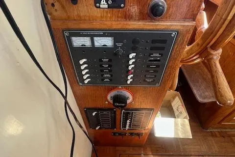 Slide: The Image of 1972 Grand Banks Trawler control panel with gauges and switches, wooden helm visible. - 4