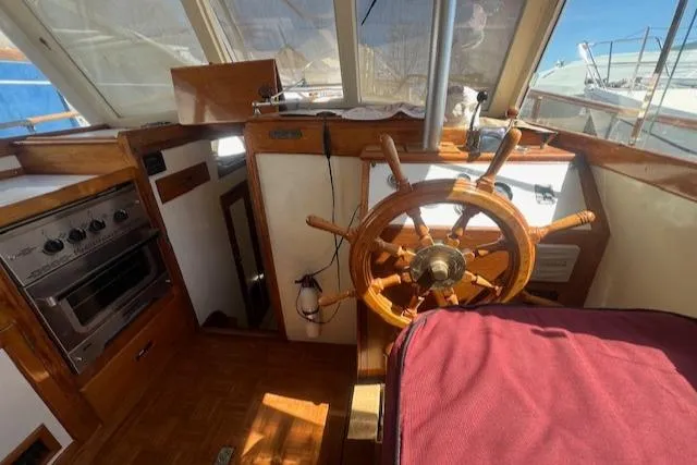 Slide: The Image of 1972 Grand Banks Trawler helm with wooden wheel and vintage interior. - 6