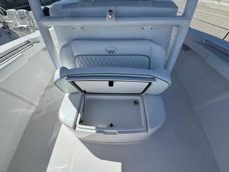 Slide: The Image of 2024 Southport 30 FE boat with open storage compartment and cushioned seating. - 11