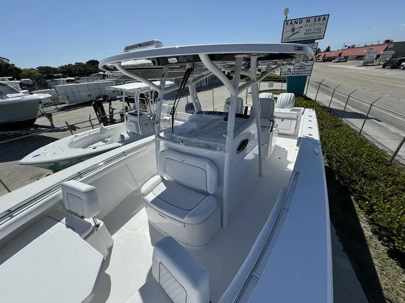 Slide: The Image of 2024 Southport 30 FE boat at a marina, showcasing spacious deck and seating. - 12
