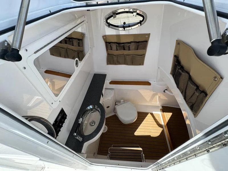 Slide: The Image of 2024 Southport 30 FE boat interior with sink, toilet, and storage compartments. - 14