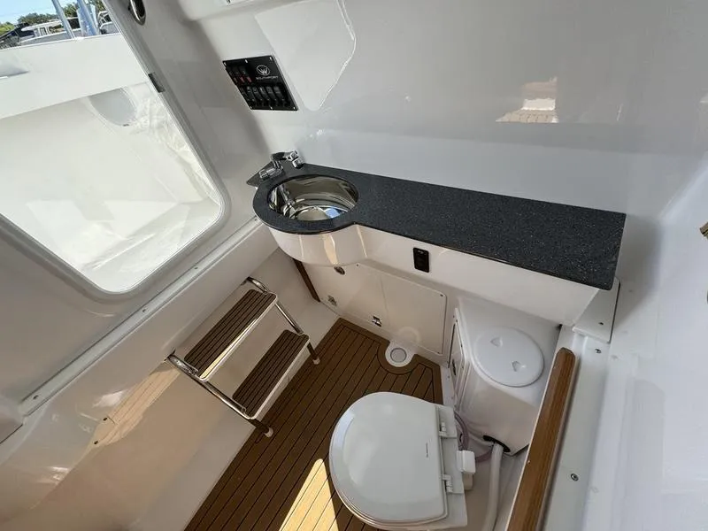 Slide: The Image of 2024 Southport 30 FE boat interior with sink, toilet, and wooden flooring. - 16
