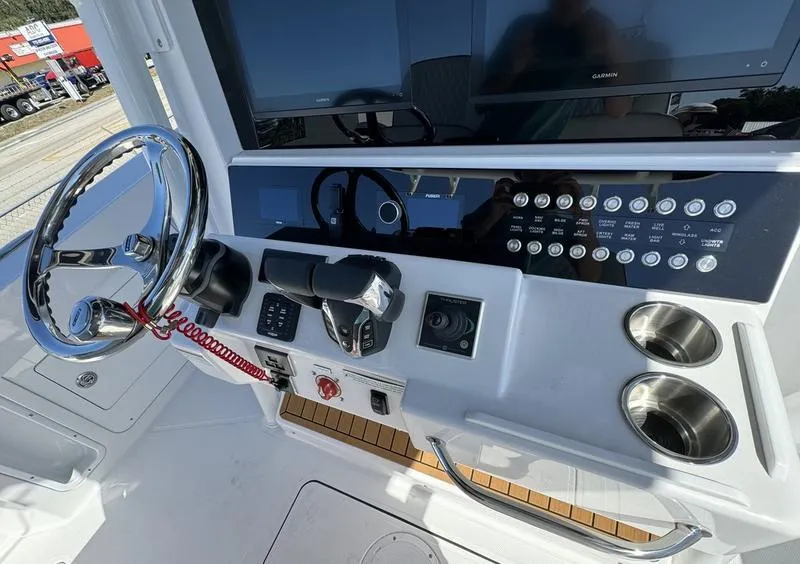 Slide: The Image of 2024 Southport 30 FE boat dashboard with steering wheel, controls, and cup holders. - 21