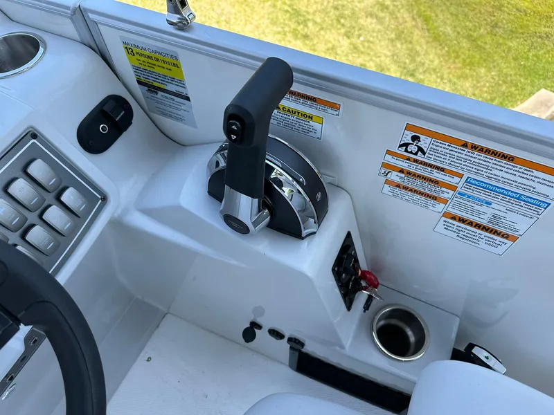 Slide: The Image of Control panel of 2024 Hurricane FunDeck 2260 RE OB boat with throttle and warning labels. - 12