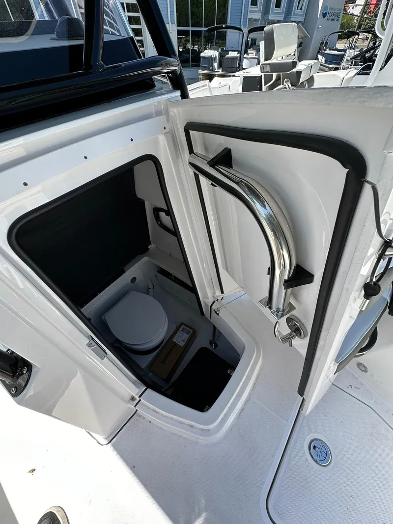 Slide: The Image of 2024 Blackfin 252 CC boat interior with open door revealing a compact marine toilet. - 10