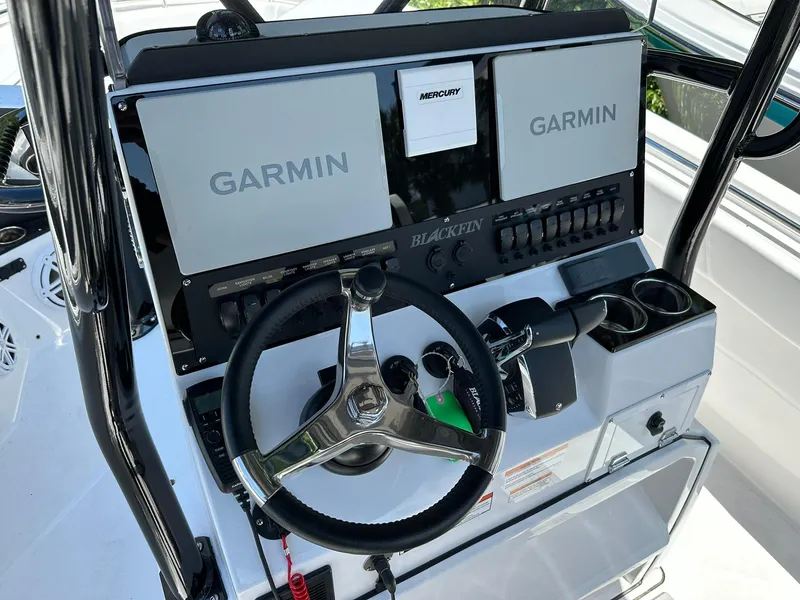 Slide: The Image of 2024 Blackfin 252 CC boat dashboard with Garmin navigation systems and Mercury controls. - 12