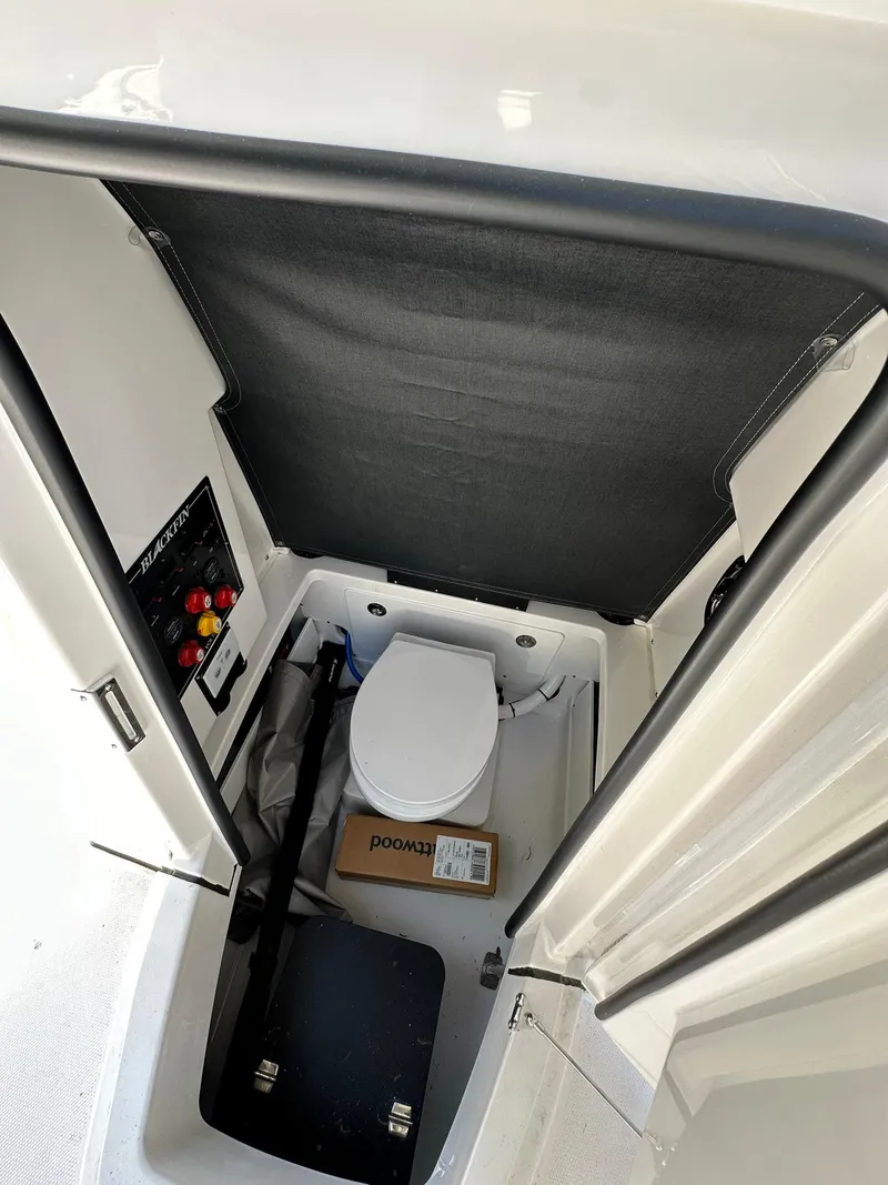 Slide: The Image of 2024 Blackfin 252 CC boat interior with marine toilet and control panel. - 9