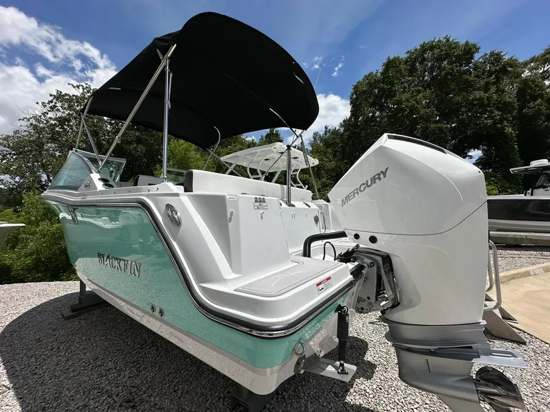 Slide: The Image of 2024 Blackfin 232 DC boat with Mercury engine on trailer, featuring sleek design and canopy. - 4