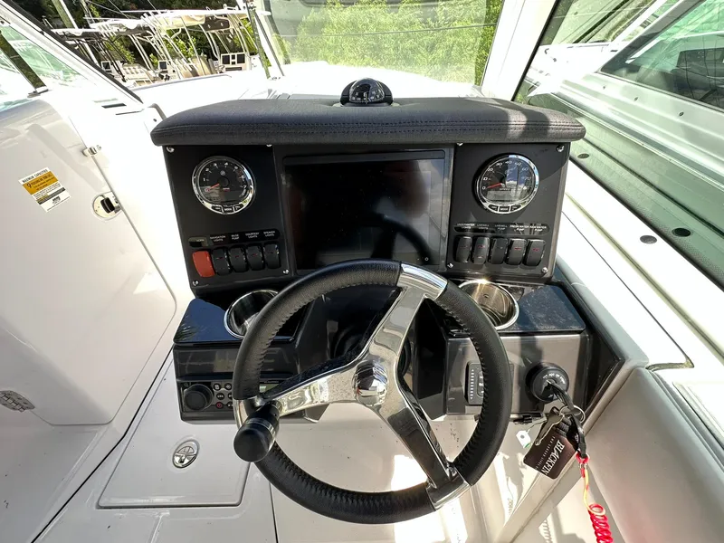Slide: The Image of 2024 Blackfin 232 DC boat dashboard with steering wheel and control panel. - 8