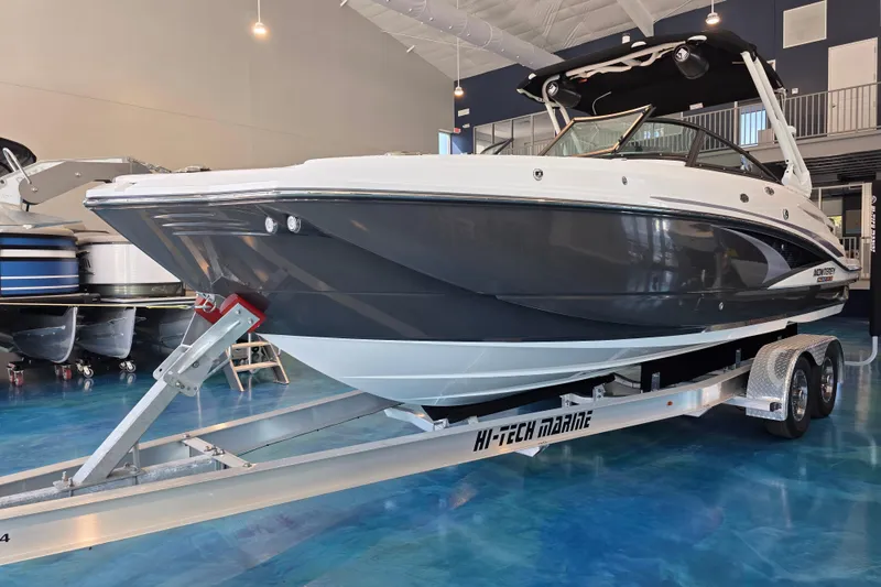 Slide: The Image of 2024 Monterey M-65 boat on trailer in showroom, sleek design, modern features. - 0