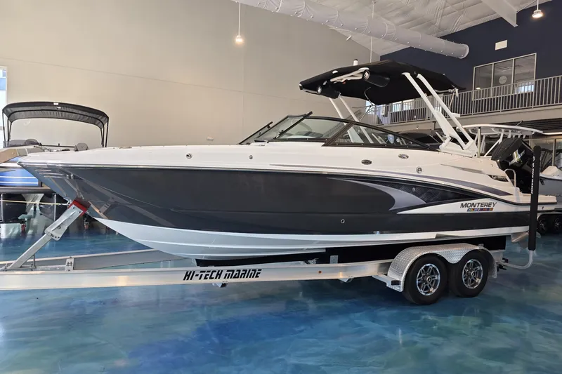 Slide: The Image of 2024 Monterey M-65 boat on trailer in showroom, featuring sleek design and modern features. - 2