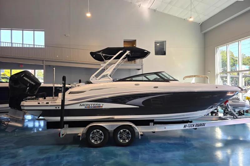 Slide: The Image of 2024 Monterey M-65 boat displayed indoors on a trailer. - 5