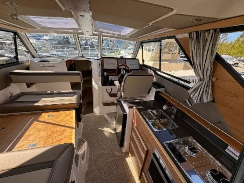 Slide: The Image of 2024 Cutwater C-288 C LE boat interior with helm, seating, and kitchen area. - 6