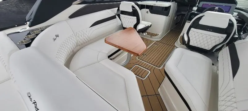 Slide: The Image of Luxurious 2024 Sea Ray SLX 260 boat interior with white seating and wood accents. - 10