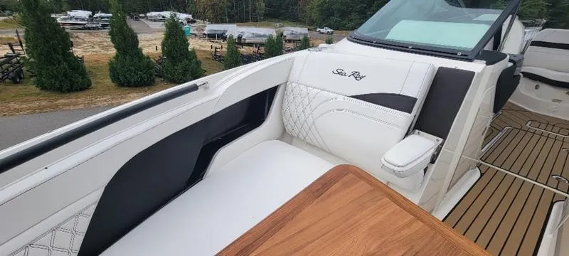 Slide: The Image of 2024 Sea Ray SLX 260 boat interior with white seating and wooden accents. - 11