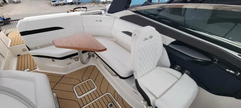 Slide: The Image of Luxurious 2024 Sea Ray SLX 260 boat interior with white seating and wooden table. - 13