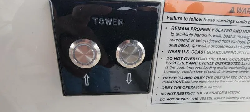 Slide: The Image of Control panel with tower buttons and safety instructions on a 2024 Sea Ray SLX 260 boat. - 14