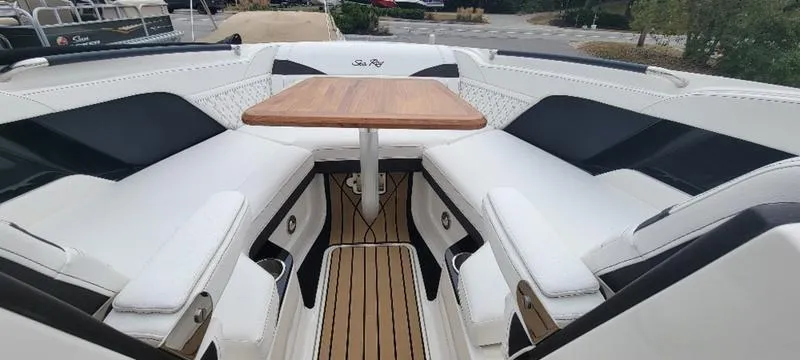 Slide: The Image of 2024 Sea Ray SLX 260 boat interior with elegant seating and wooden table. - 18