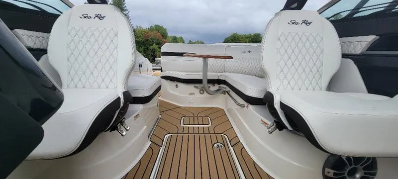Slide: The Image of 2024 Sea Ray SLX 260 boat interior with white seating and teak flooring. - 21