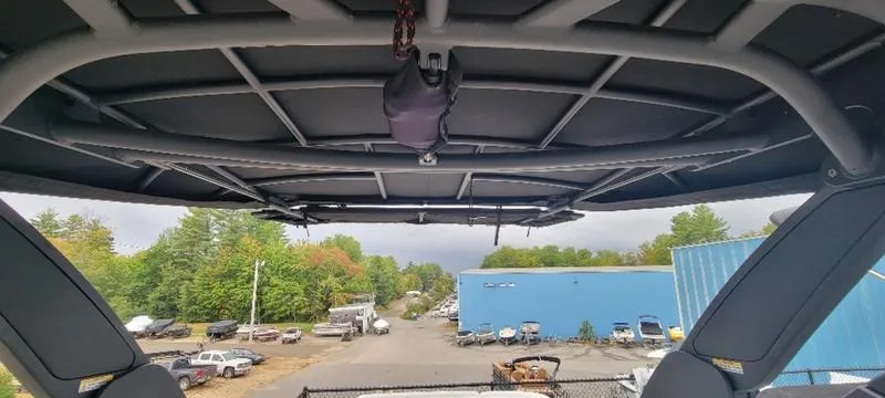 Slide: The Image of 2024 Sea Ray SLX 260 boat interior view with canopy, overlooking a marina. - 23