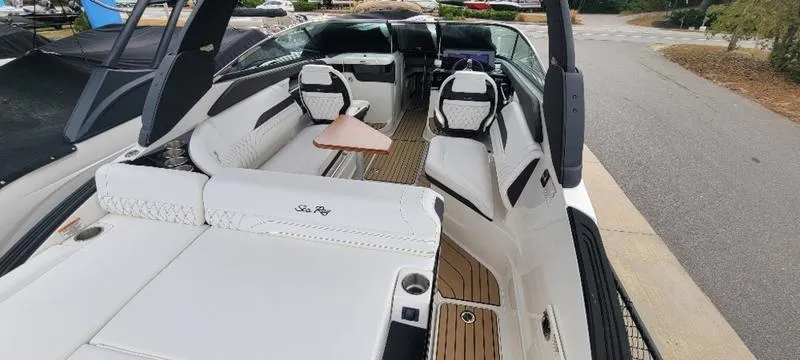 Slide: The Image of 2024 Sea Ray SLX 260 boat interior with white seating and wooden flooring. - 4