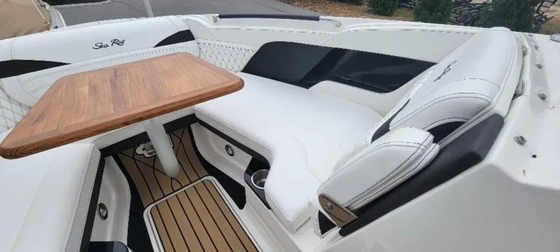 Slide: The Image of 2024 Sea Ray SLX 260 boat interior with white seating and wooden table. - 5