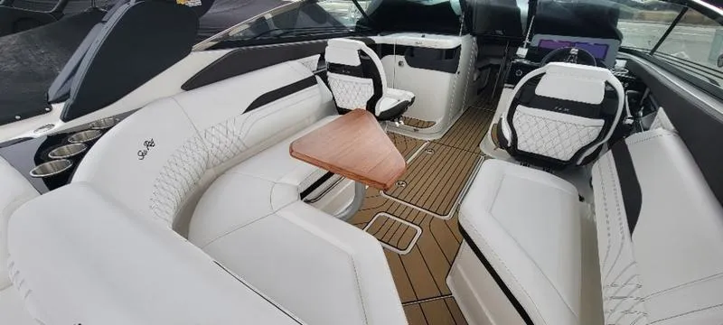 Slide: The Image of Luxurious interior of 2024 Sea Ray SLX 260 boat with white seating and wooden flooring. - 7