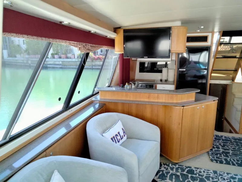 Slide: The Image of Interior of Bayliner 4788 yacht with cozy seating, TV, and large windows. - 18