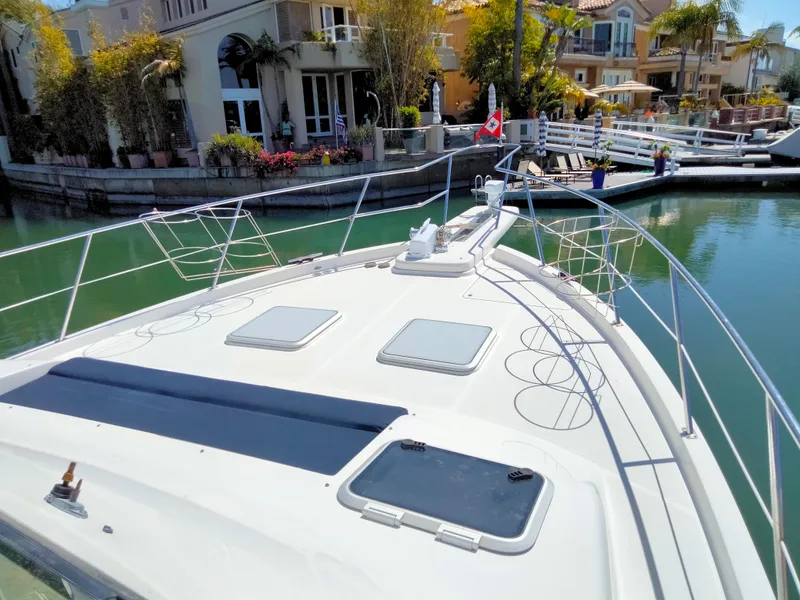 Slide: The Image of 1998 Bayliner 4788 Motoryacht docked in a scenic harbor. - 2