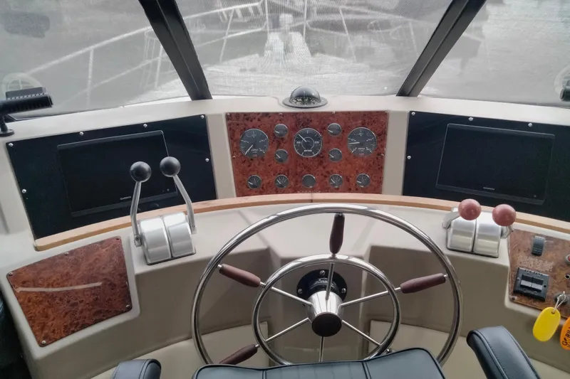 Slide: The Image of 1998 Bayliner 4788 Pilot House Motoryacht helm with steering wheel and control panels. - 26