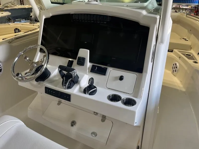Slide: The Image of 2025 Sailfish 312 CC boat dashboard with steering wheel and control panel. - 11