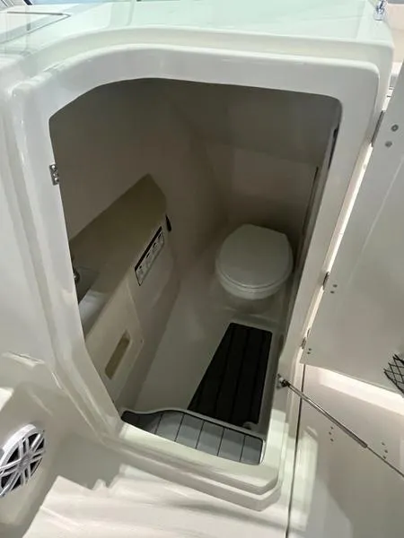 Slide: The Image of 2025 Sailfish 276 DC boat interior bathroom with toilet and storage. - 7