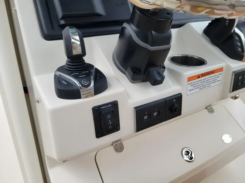 Slide: The Image of Close-up of 2025 Sailfish 272 CC boat control panel with joystick and switches. - 16