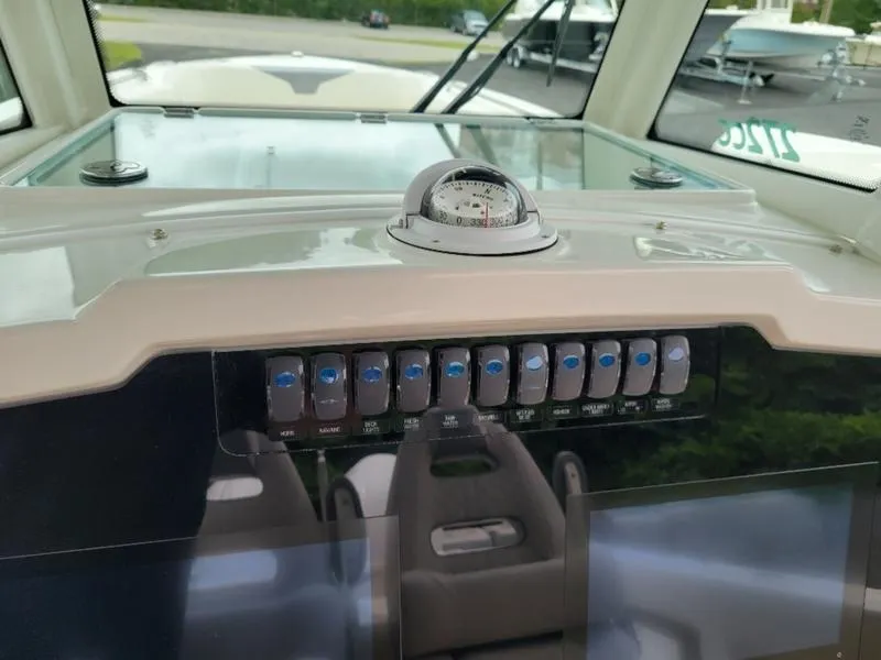 Slide: The Image of 2025 Sailfish 272 CC boat dashboard with compass and control switches. - 19
